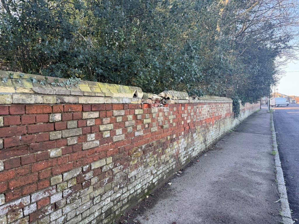 Lot: 112 - OVER HALF AN ACRE OF FREEHOLD PARCEL OF LAND - Shot showing damage to brick of wall